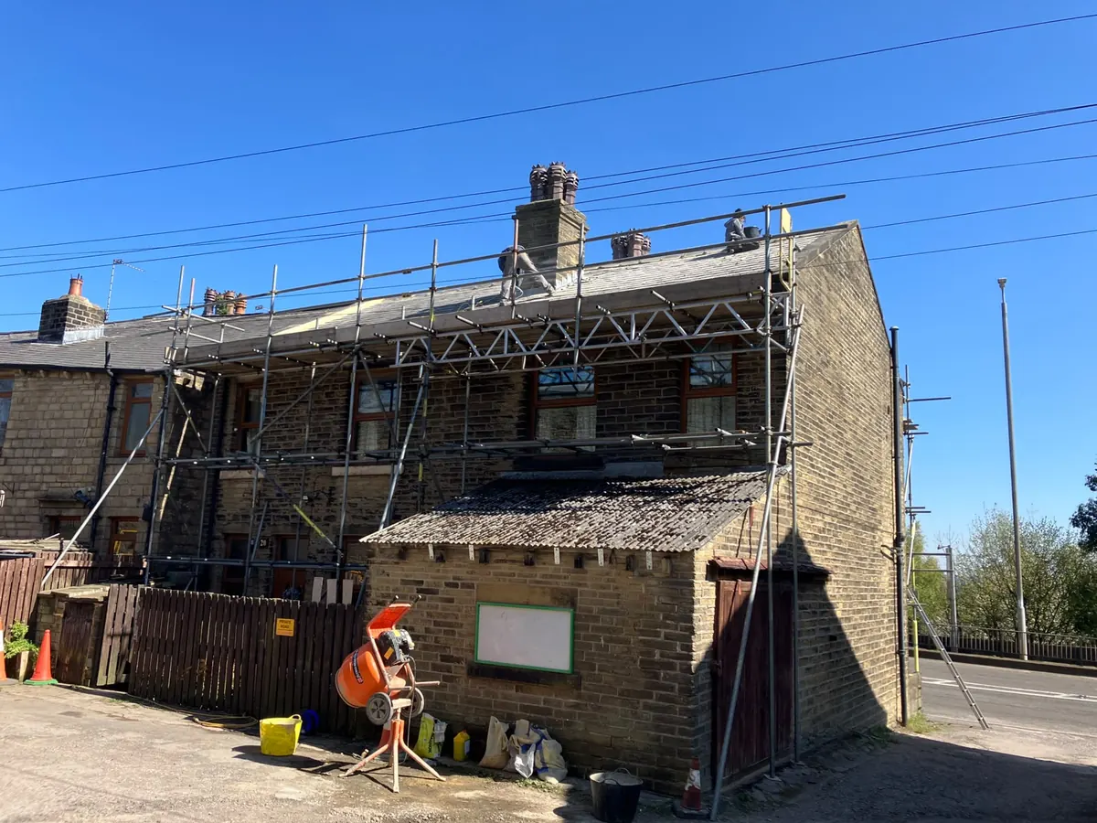 Full scaffold around a Halifax stone terrace part-way through a complete re-roof