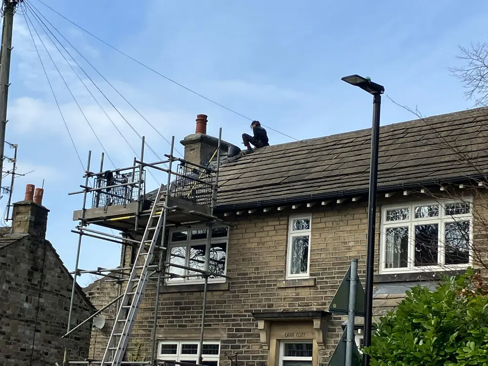 Scaffolded semi-detached house in Halifax during roofline and roof window works